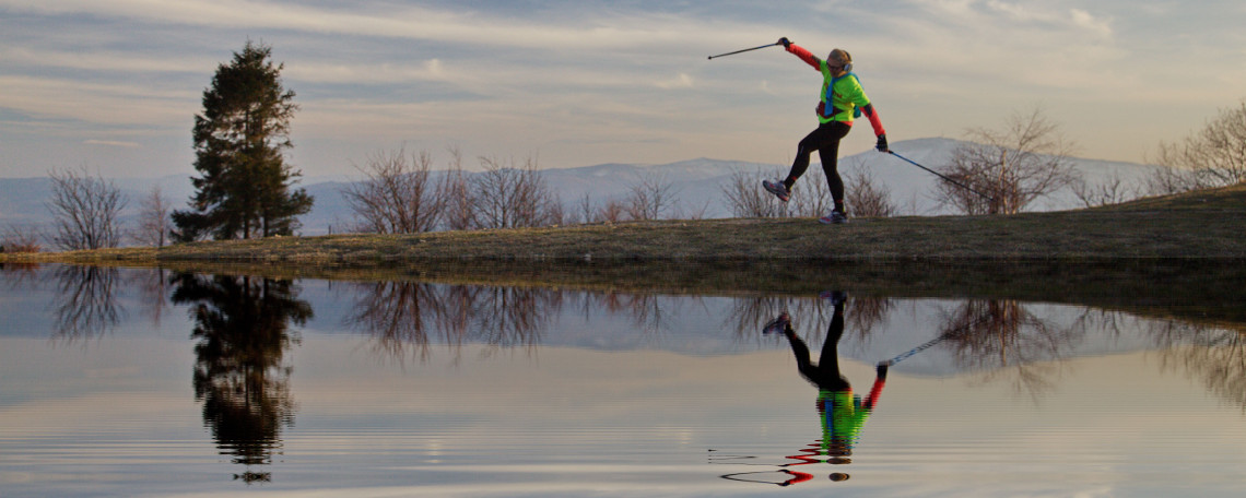 Zdjęcie osoby ćwiczącej nordic walking. W tle Beskidy
