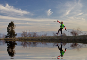 Zdjęcie osoby ćwiczącej nordic walking. W tle Beskidy